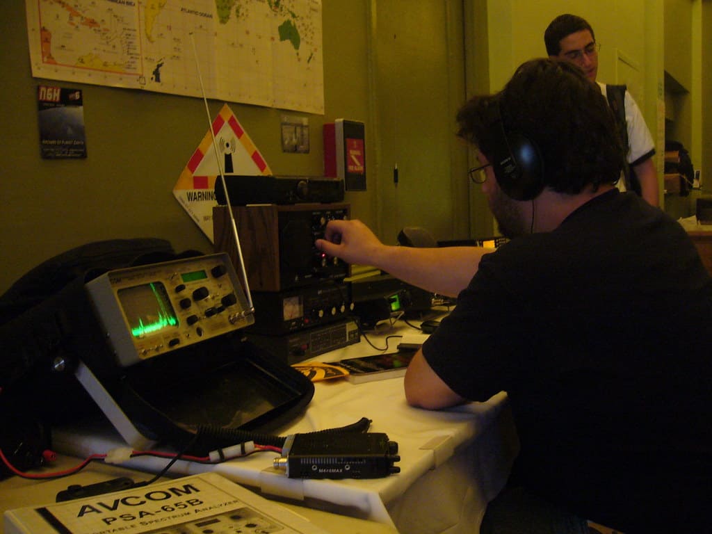 This is an action shot of an operator making their first contact, wearing headphones, speaking into the microphone, or recording their interaction.
