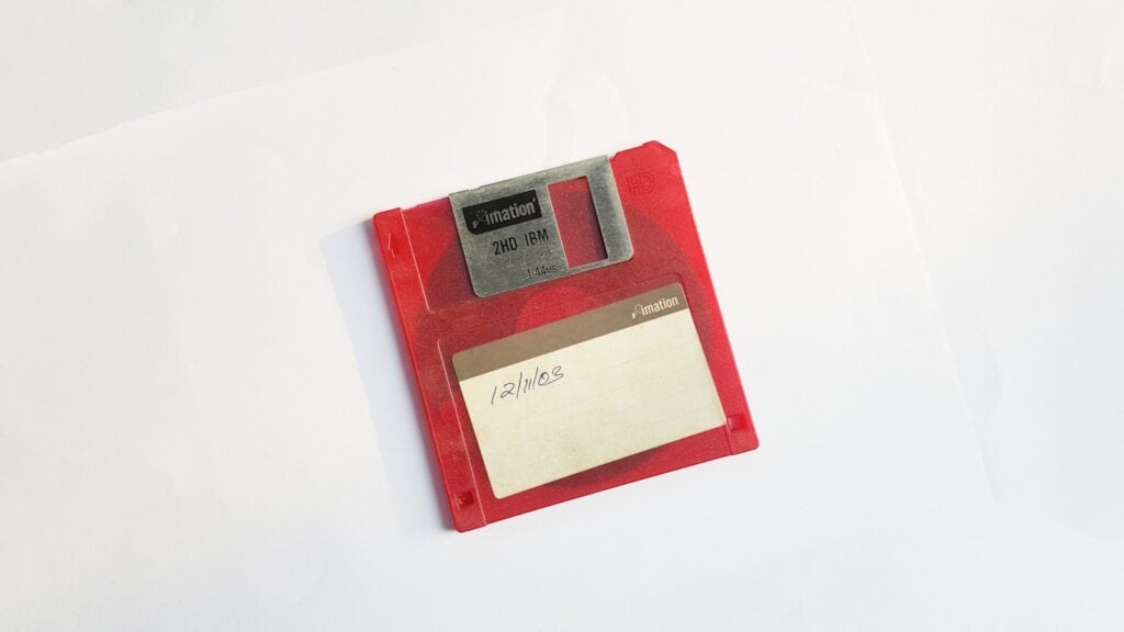 red and white floppy disk on a white surface 